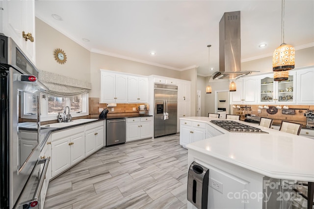 kitchen featuring decorative light fixtures, sink, island exhaust hood, appliances with stainless steel finishes, and white cabinets