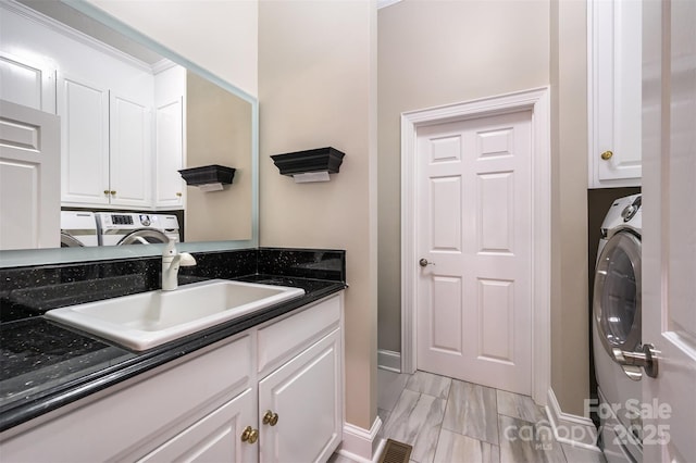 washroom with cabinets, sink, and washer / clothes dryer