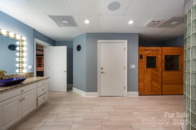 bathroom featuring a paneled ceiling and vanity