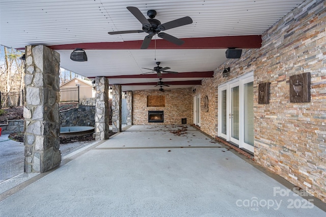 view of patio featuring ceiling fan and an outdoor stone fireplace