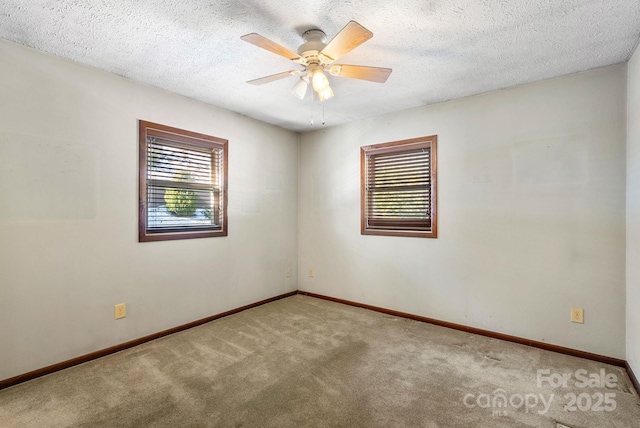 empty room featuring ceiling fan, carpet, and a textured ceiling