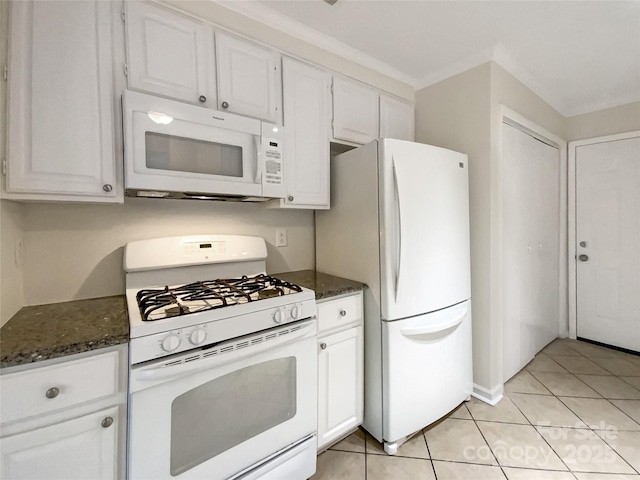 kitchen with light tile patterned flooring, white cabinets, dark stone counters, and white appliances