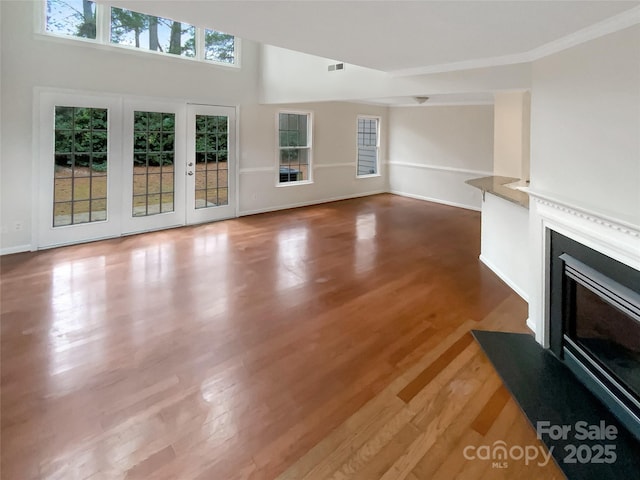 unfurnished living room with crown molding and hardwood / wood-style flooring