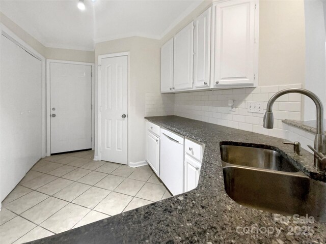 kitchen with dishwasher, backsplash, white cabinets, sink, and light tile patterned floors