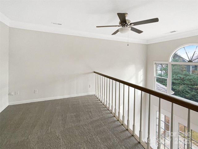 hall with dark colored carpet and ornamental molding