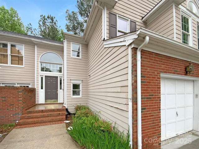 entrance to property with brick siding and a garage