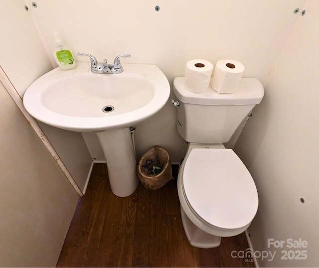 bathroom with hardwood / wood-style flooring and toilet