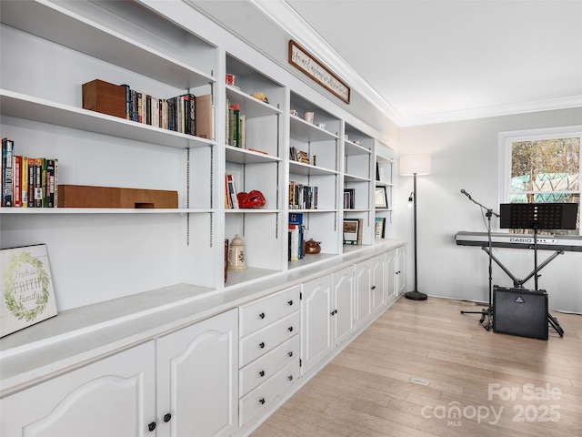 office space featuring light wood-type flooring and crown molding