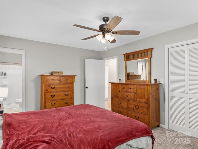 carpeted bedroom with ensuite bathroom, ceiling fan, and a closet