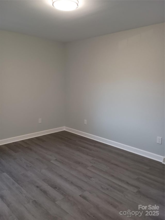 spare room featuring dark wood-type flooring