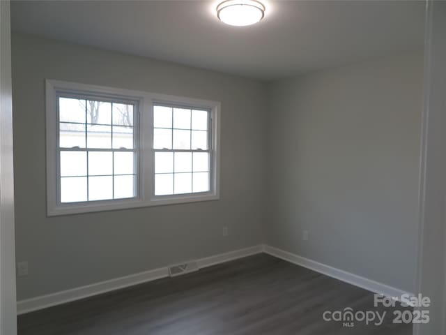 unfurnished room with dark wood-type flooring