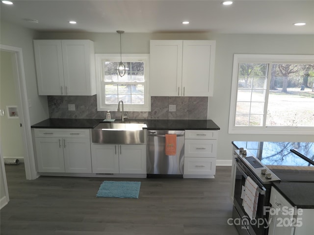 kitchen with white cabinetry, appliances with stainless steel finishes, sink, and decorative light fixtures