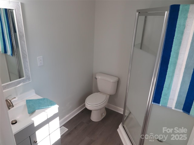 bathroom with vanity, a shower with shower door, toilet, and wood-type flooring