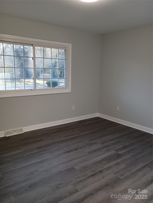 spare room with dark hardwood / wood-style flooring