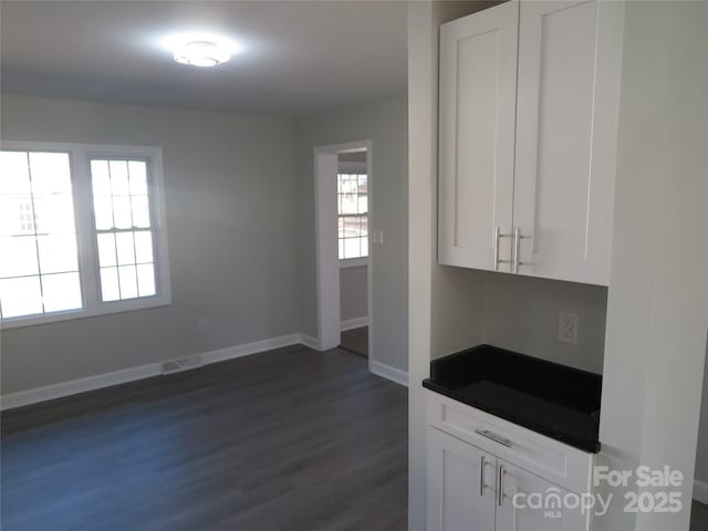 kitchen with dark wood-type flooring and white cabinets