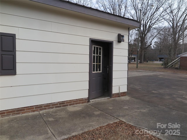 view of exterior entry featuring a patio area