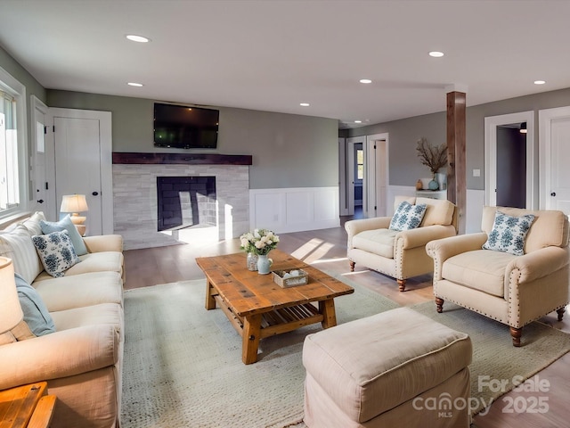 living room featuring a tile fireplace and hardwood / wood-style flooring