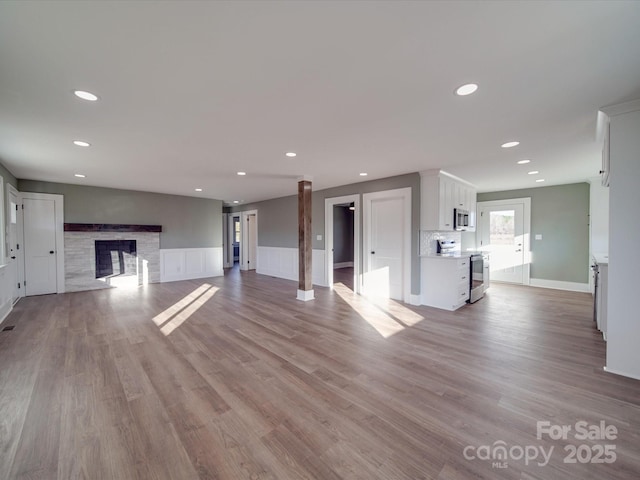 unfurnished living room with a fireplace and light wood-type flooring