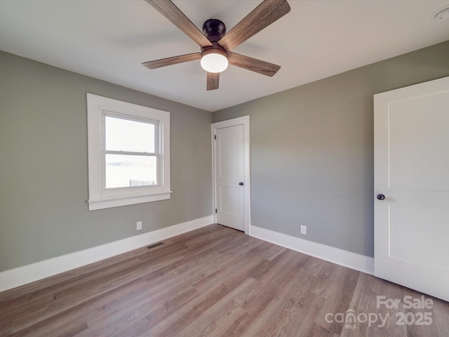 unfurnished room with light wood-type flooring and ceiling fan