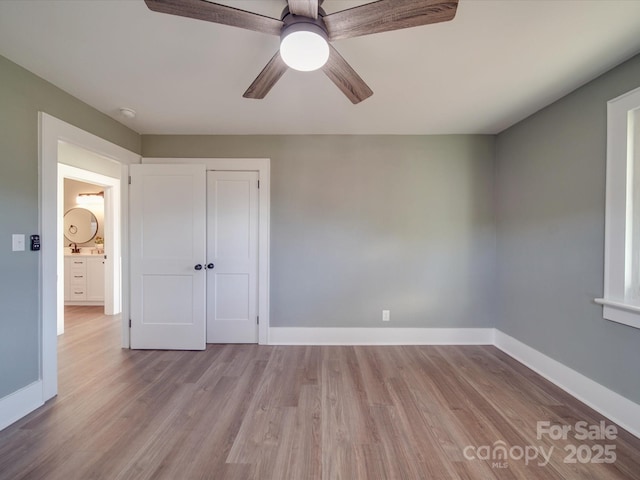 unfurnished bedroom featuring ceiling fan, a closet, and light hardwood / wood-style floors