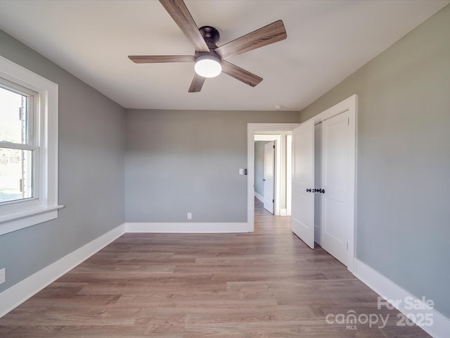 unfurnished room with ceiling fan and light wood-type flooring