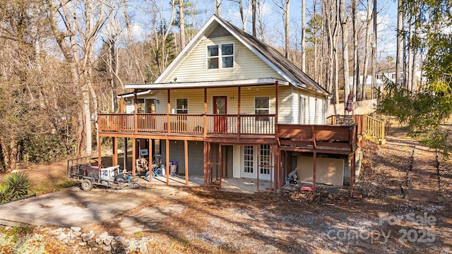 back of property with a wooden deck and french doors