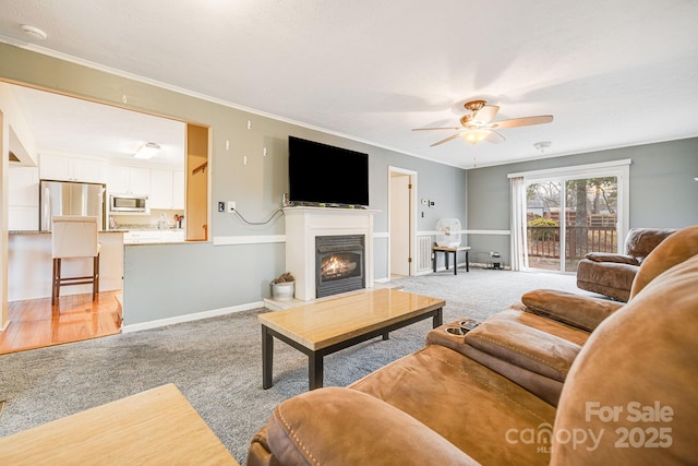 living room featuring ceiling fan, light colored carpet, and ornamental molding