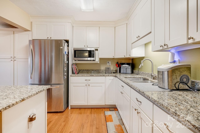 kitchen featuring white cabinetry, sink, and appliances with stainless steel finishes