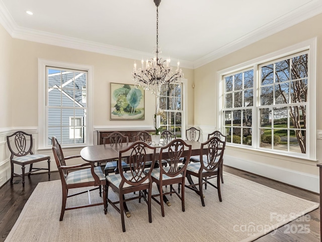 dining space with dark hardwood / wood-style floors, ornamental molding, plenty of natural light, and a notable chandelier