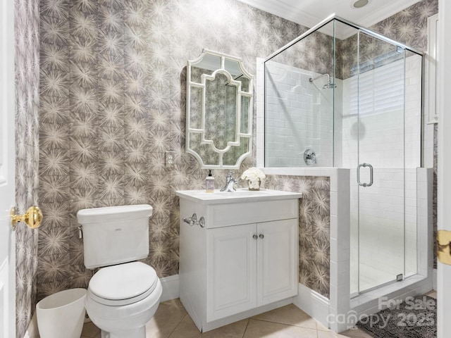 bathroom with tile patterned floors, vanity, toilet, a shower with shower door, and crown molding