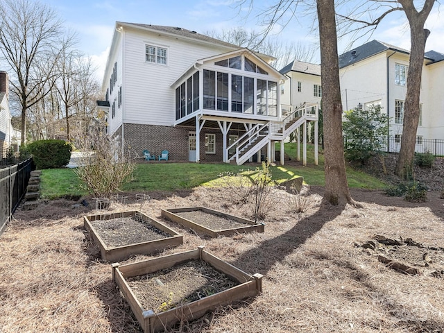 rear view of property featuring a sunroom and a yard