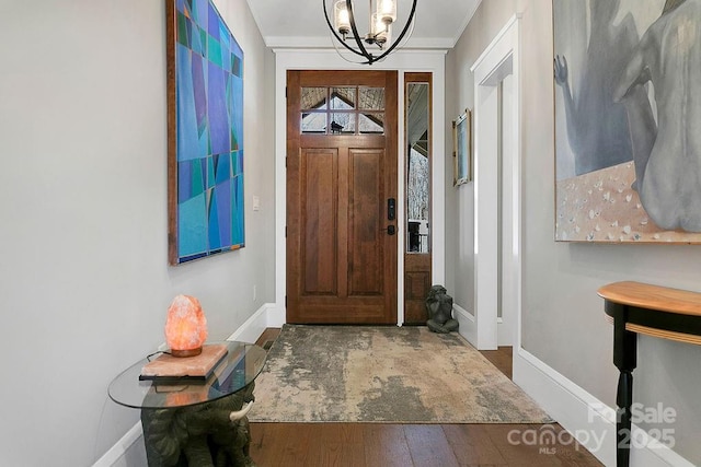 foyer entrance with hardwood / wood-style floors and a notable chandelier