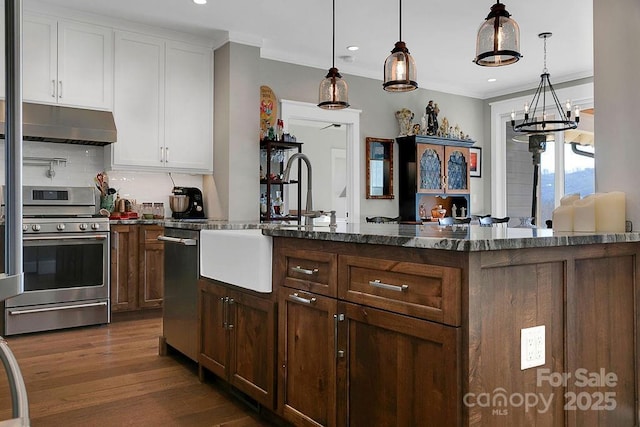 kitchen featuring sink, appliances with stainless steel finishes, white cabinets, decorative backsplash, and decorative light fixtures