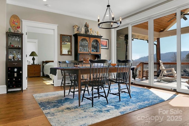 dining space with an inviting chandelier, a mountain view, and wood-type flooring