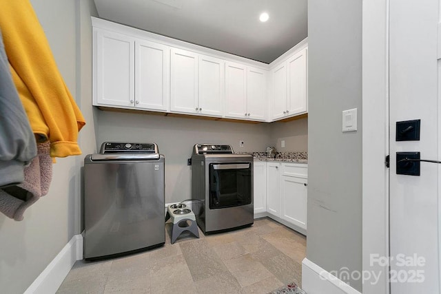 laundry area with cabinets and washer and clothes dryer