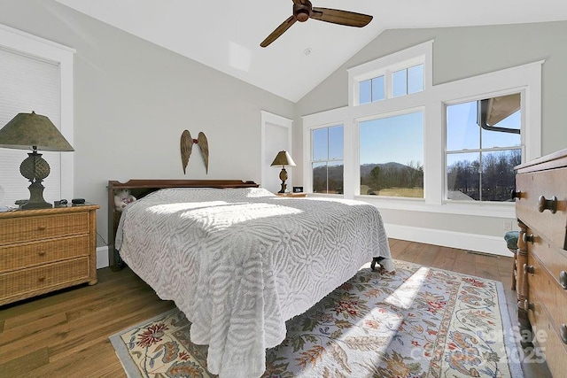 bedroom featuring dark hardwood / wood-style flooring, vaulted ceiling, and ceiling fan