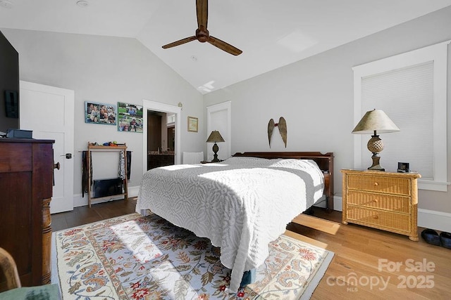 bedroom featuring hardwood / wood-style flooring, ceiling fan, lofted ceiling, and ensuite bath