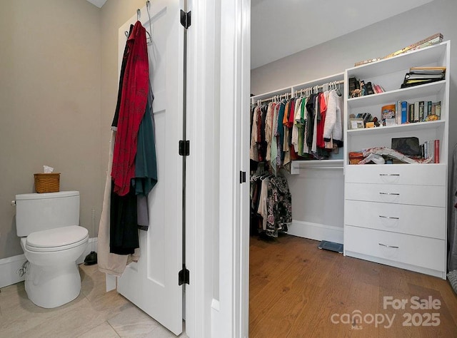 interior space with wood-type flooring and toilet