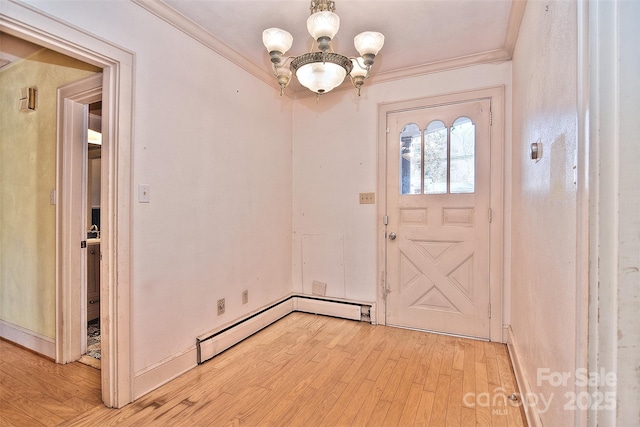 entrance foyer with a notable chandelier, light hardwood / wood-style flooring, ornamental molding, and a baseboard radiator