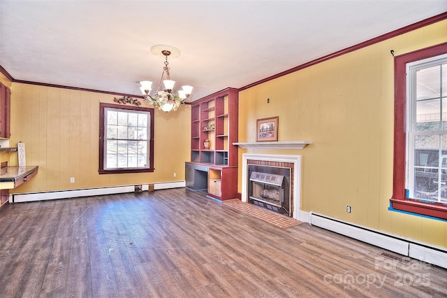 unfurnished living room with a notable chandelier, baseboard heating, a brick fireplace, and ornamental molding