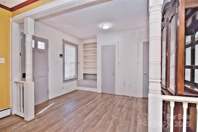 foyer entrance featuring hardwood / wood-style floors and crown molding