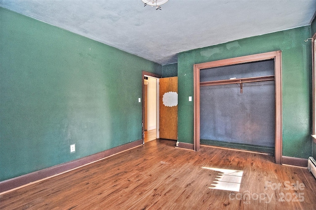 unfurnished bedroom featuring a closet and hardwood / wood-style flooring