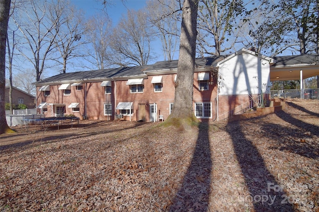 rear view of property with a trampoline