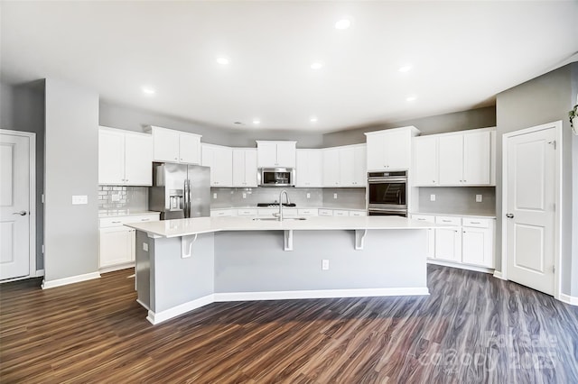 kitchen with stainless steel appliances, white cabinetry, and a spacious island