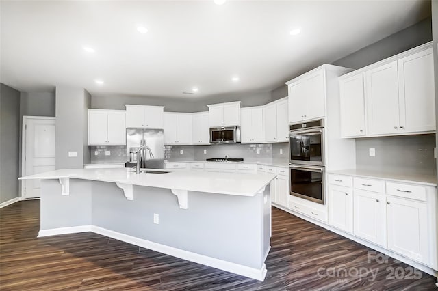 kitchen with appliances with stainless steel finishes, white cabinetry, and a spacious island