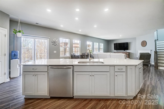 kitchen featuring dishwasher, a center island with sink, dark hardwood / wood-style flooring, white cabinetry, and sink