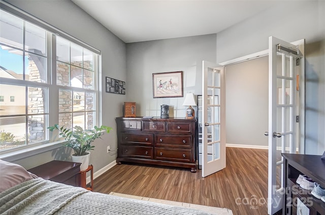 bedroom with french doors and hardwood / wood-style floors