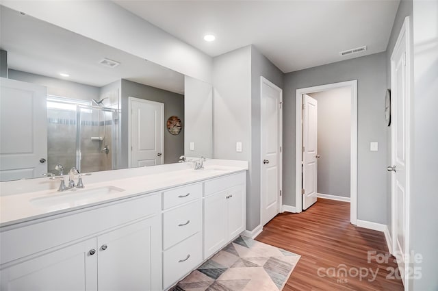 bathroom featuring vanity, hardwood / wood-style floors, and a shower with shower door