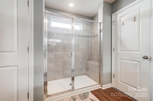 bathroom with walk in shower and hardwood / wood-style floors