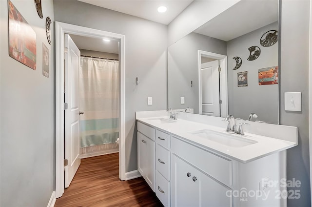 bathroom with hardwood / wood-style floors, vanity, and curtained shower